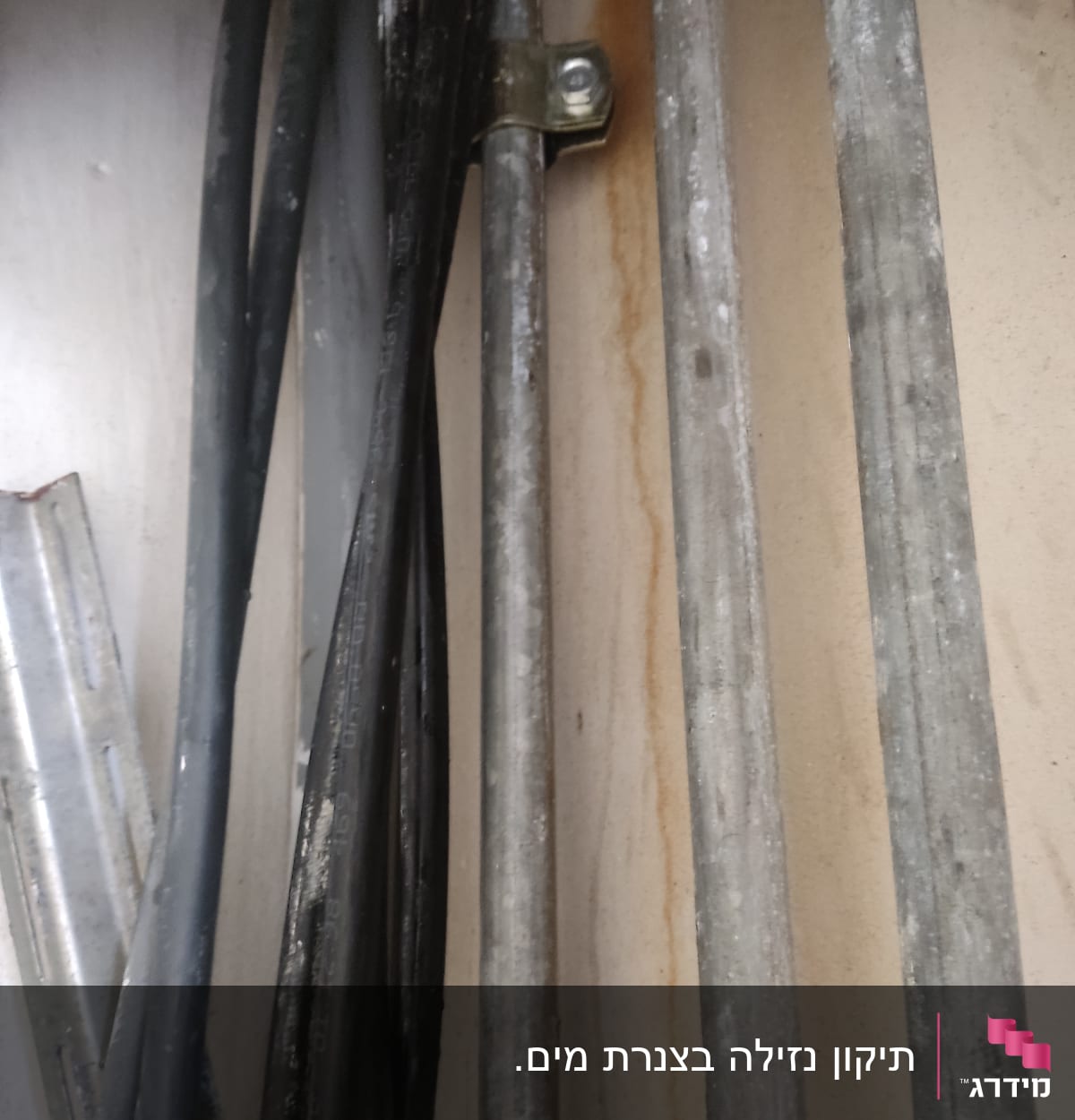 צינורות מתכת עם תפסן על קיר